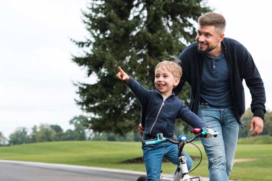 Father and child with bike in park