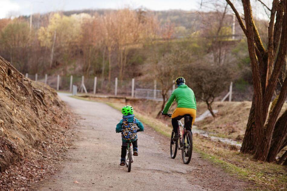 Father and son cycling together in a park