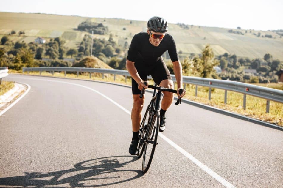 Athletic man riding bike with background of nature