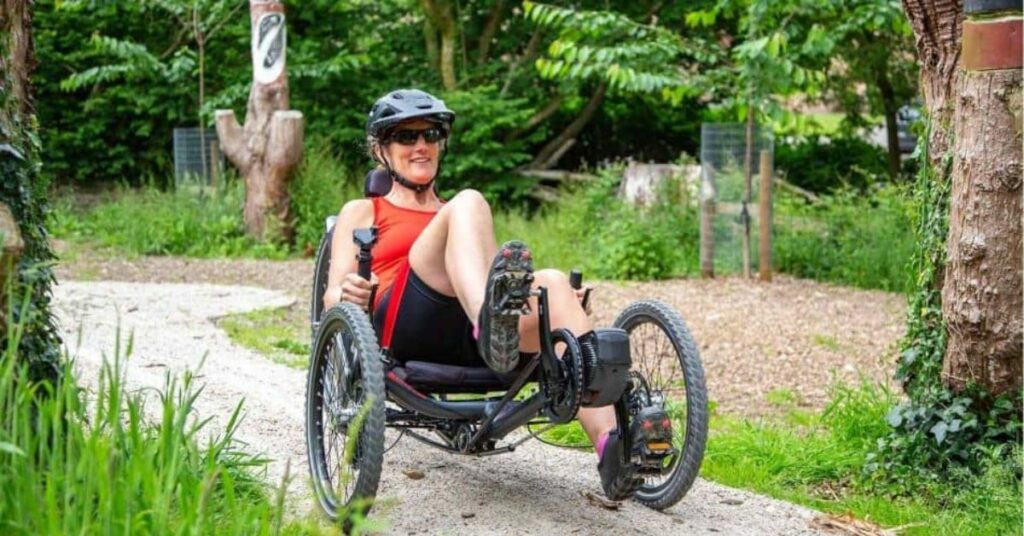 ICE Trail electric recumbent adult tricycle woman riding along gravel path 1 1