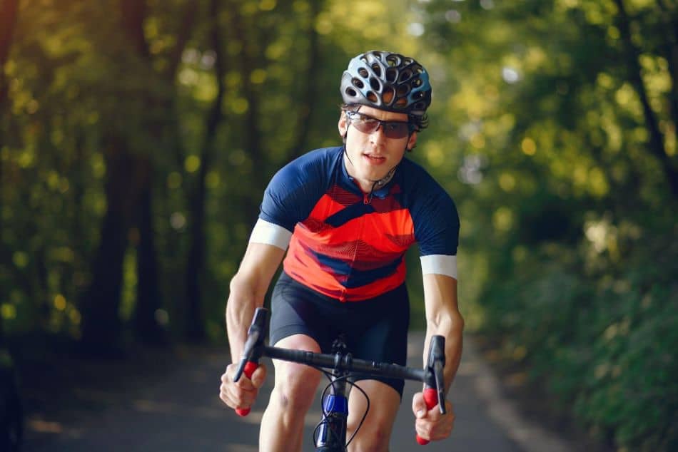 Sports man riding bike in summer forest