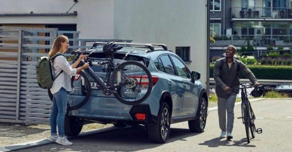 woman unloads bike from Thule trunk rack 1