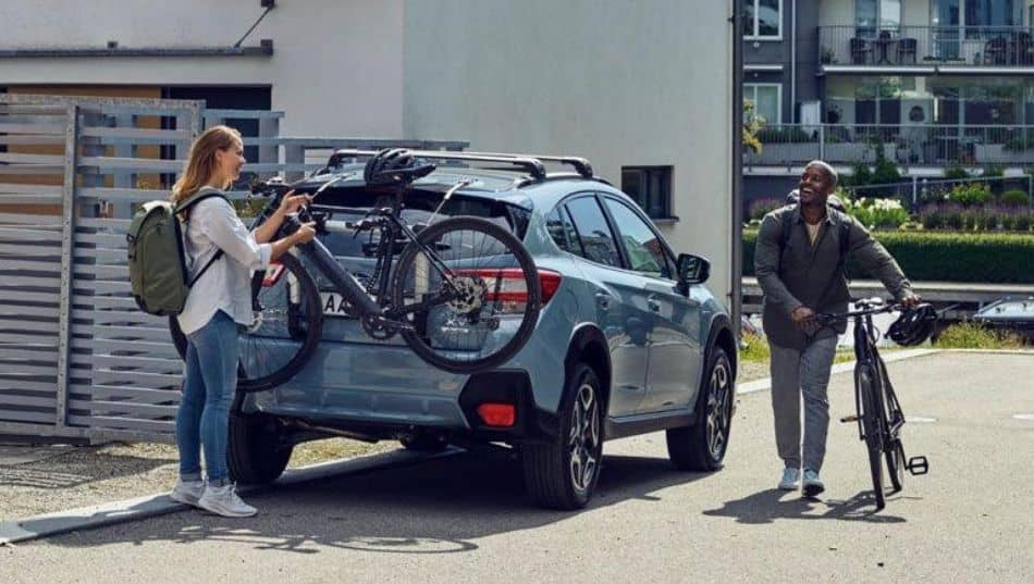 woman unloads bike from Thule trunk rack