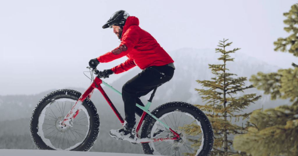 man in red jacket riding Rocky Mountain fat tire mountain bike in snow 1