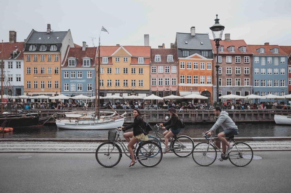 three cyclists riding along the Copenhagen riverway