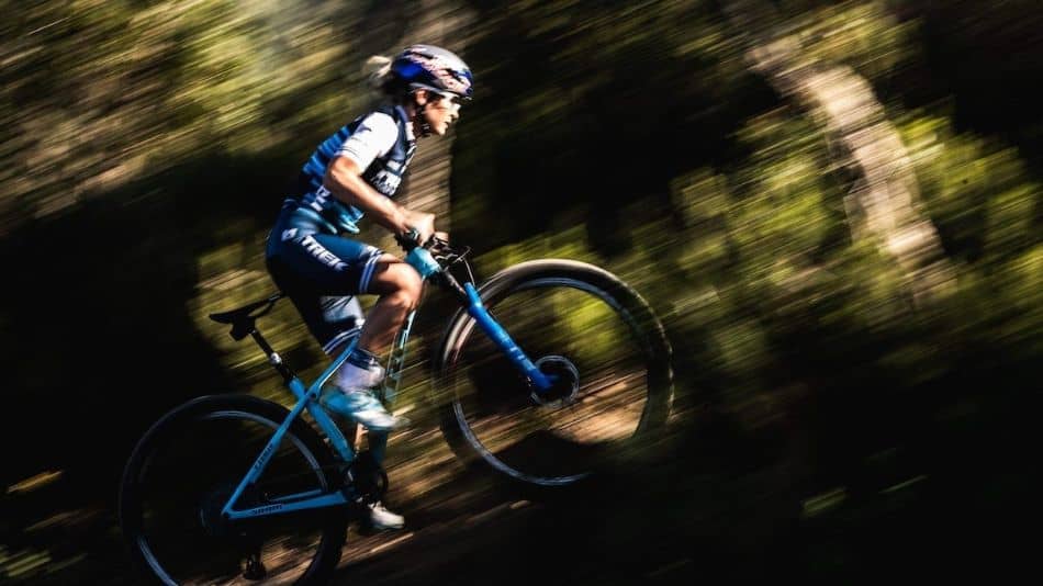 professional female mountain biker racing up the trail