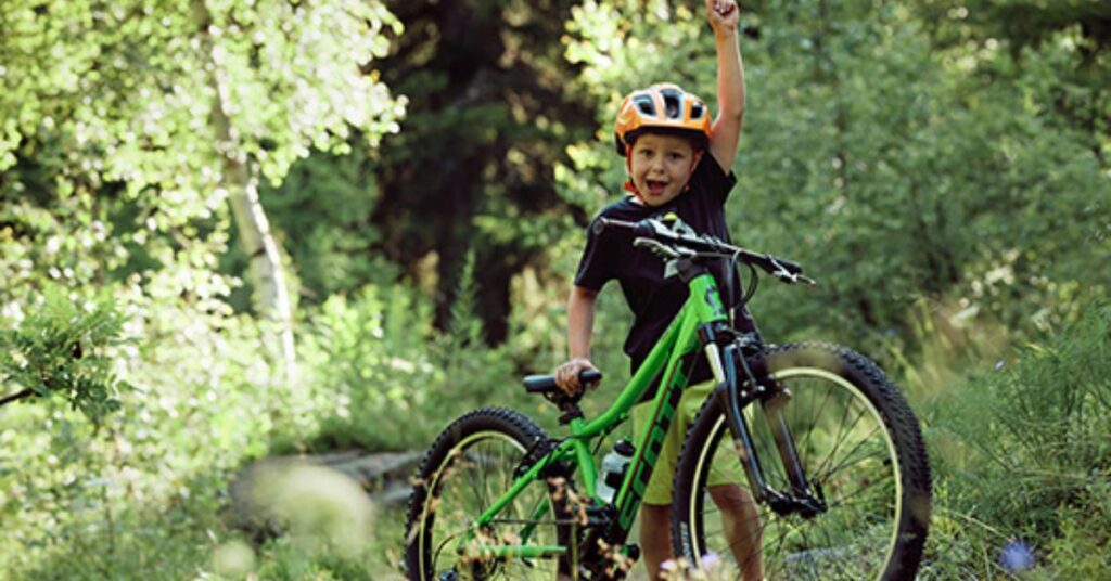 boy on green Scott mountain bike in forest1 1