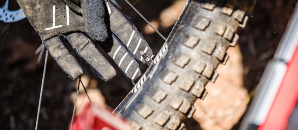Mountain biker with gloves releasing pressure on mountain bike tire 1